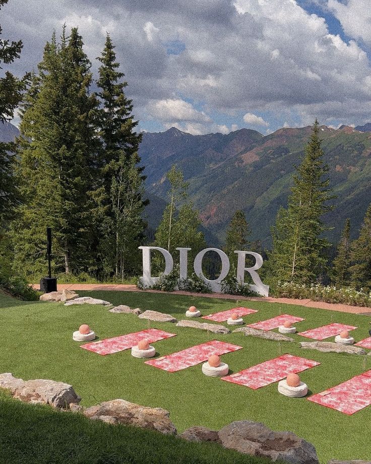 Dior branded yoga activation at The Little Nell in Aspen with branded toile de Jouy mats and mountain backdrop