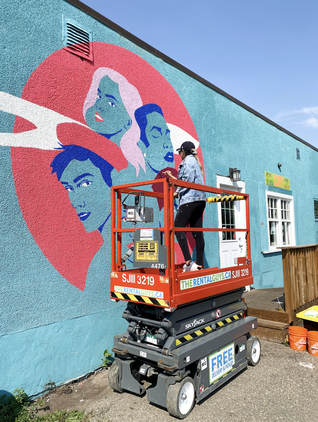 SAWA community mural installation, artists painting exterior wall, NW Calgary