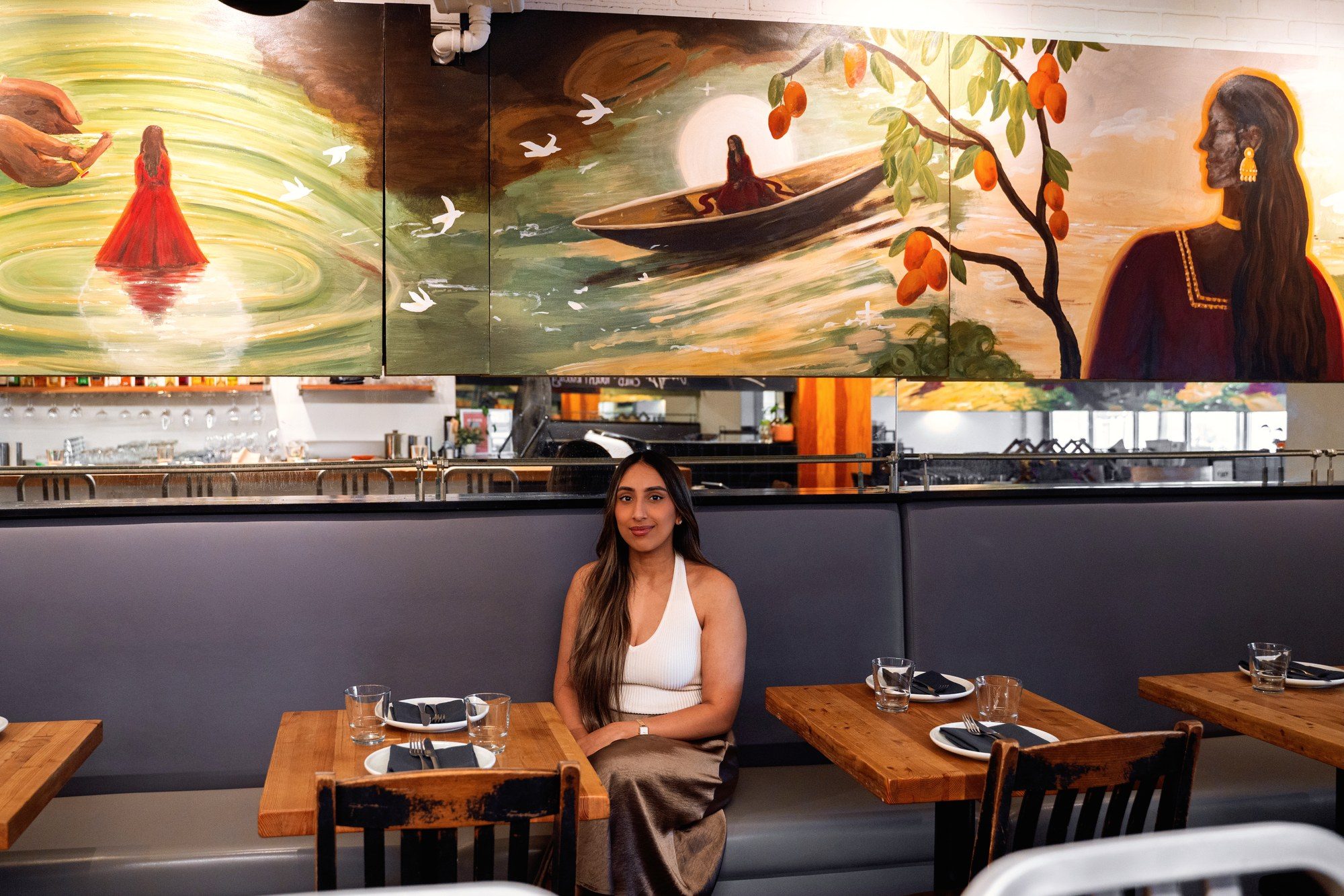 Detail of the UNA Pizza artboard: white birds crossing the centre of the panel above the bar, with a figure in a boat and a mango branch to the right