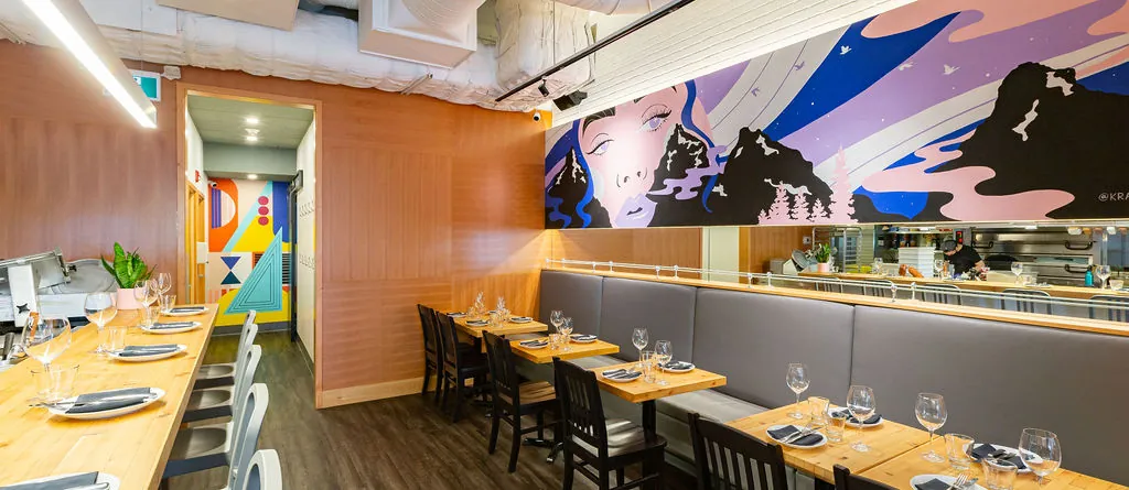 Uprooted mural detail at UNA Pizza + Wine, figurative portrait emerging from mountain landscape, interior mural by KINN Studios Calgary