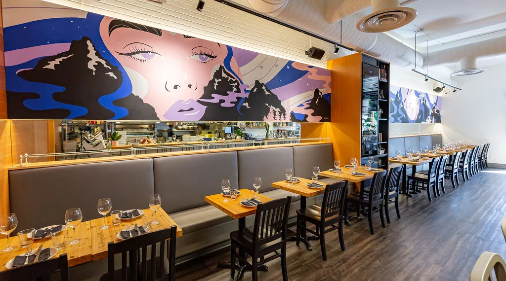 Uprooted mural at UNA Pizza + Wine showing full wall composition with figurative portrait, mountain landscape, and starlit sky above dining tables, KINN Studios Calgary